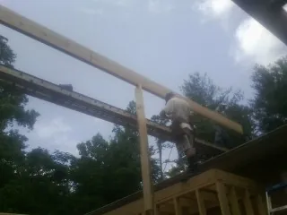 Carpenter setting a ridge beam over a new addition frame — Ice Dam Removal by Roofing Brothers in Peculiar