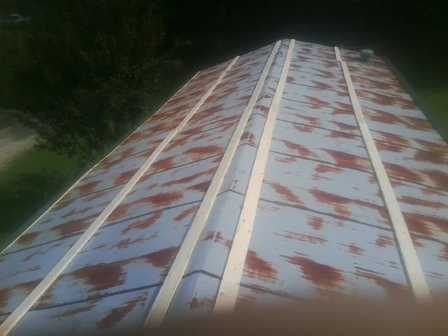 Rusted metal roof panels with new wood purlins before replacement — Storm Damage Roof Repair in Peculiar by Roofing Brothers