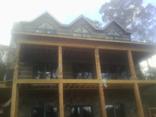 Dormers and porch framing on a large log home under construction — Roof Coating work by our crew in Peculiar